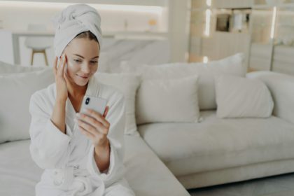 Woman beauty blogger creating video on smartphone for her vlog about daily skincare routine